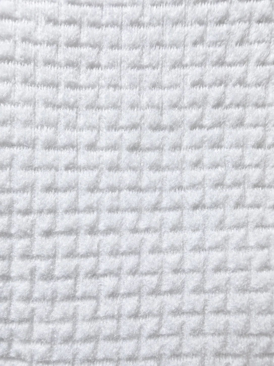 Embossed texture on a disposable face towel